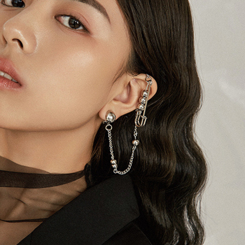 Woman wearing a unique earring with a neutral background Woman wearing a unique earring with a neutral background