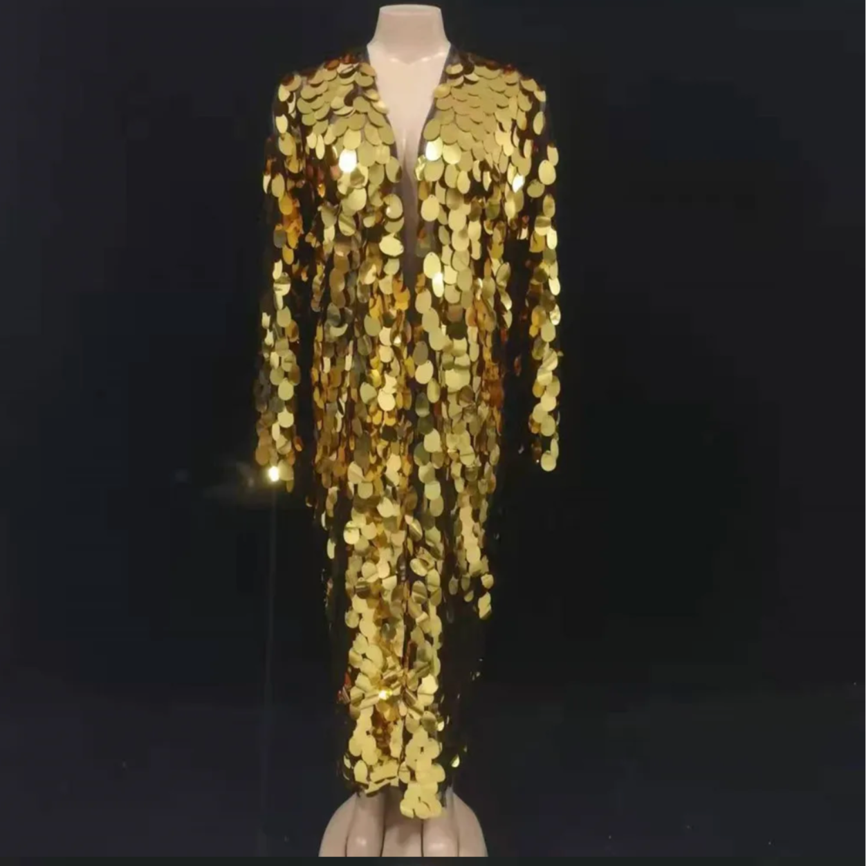 Mannequin wearing a gold sequin outfit against a black background Mannequin wearing a gold sequin outfit against a black background
