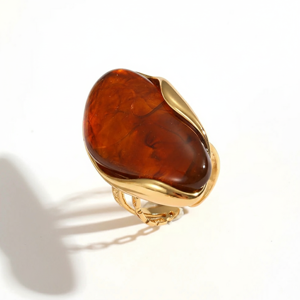 Gold ring with a large brown stone on a white background Gold ring with a large brown stone on a white background
