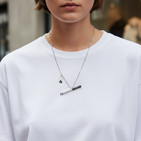 Person wearing a white t-shirt and two necklaces with a blurred background Person wearing a white t-shirt and two necklaces with a blurred background