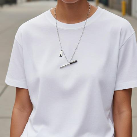 Person wearing a plain white t-shirt and a necklace with a pendant. Person wearing a plain white t-shirt and a necklace with a pendant.