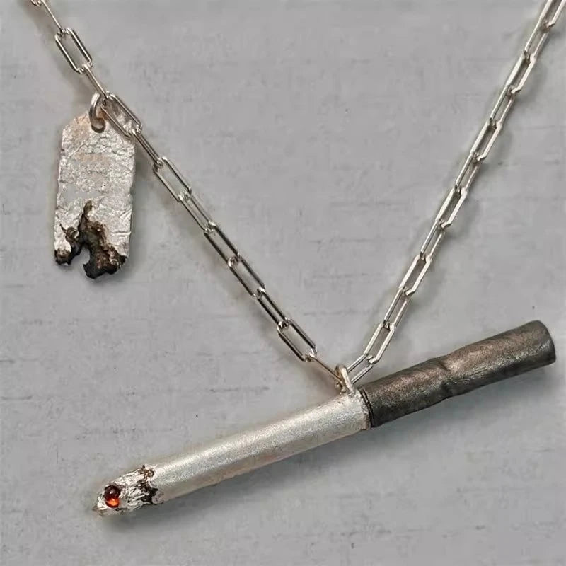 Silver necklace with a unique pendant on a gray background Silver necklace with a unique pendant on a gray background