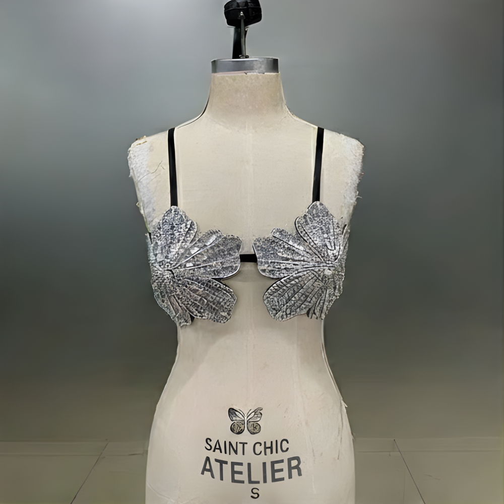 Mannequin wearing a silver embellished top with 'Saint Chic Atelier' branding on a gray background