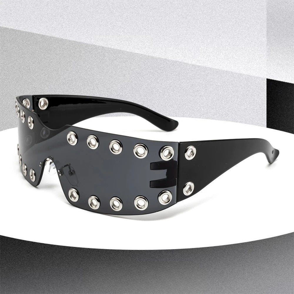 Black sunglasses with decorative studs on a gray background